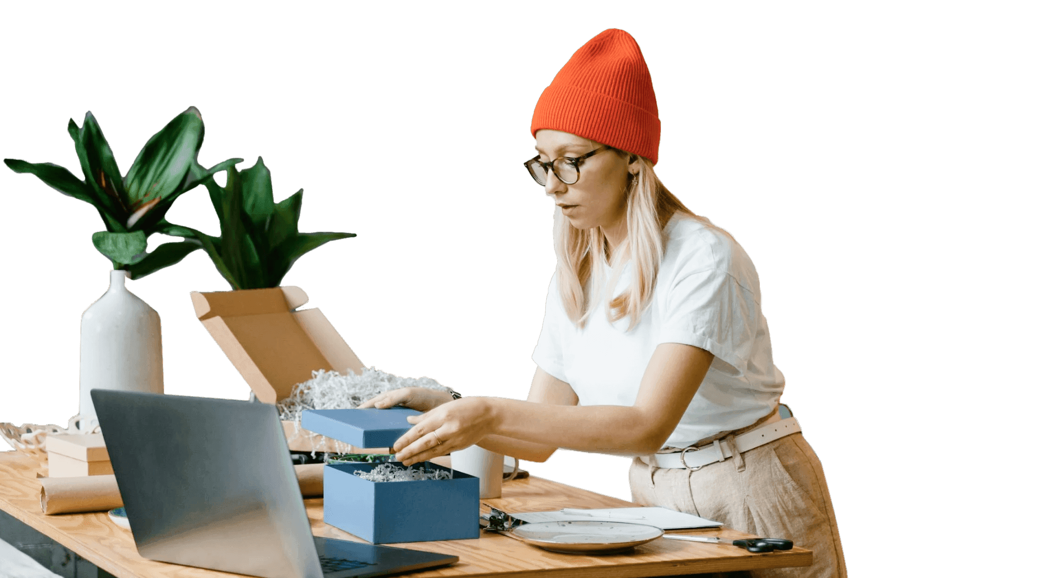 lady packaging box near table with laptop